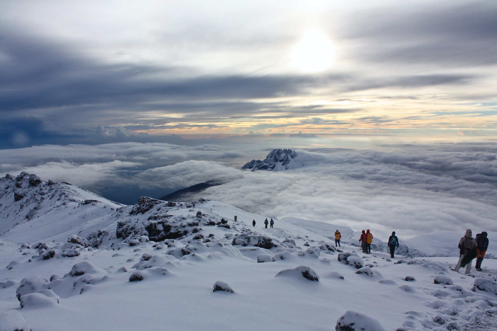 Climbers on the snowy Kilimanjaro summit above the clouds